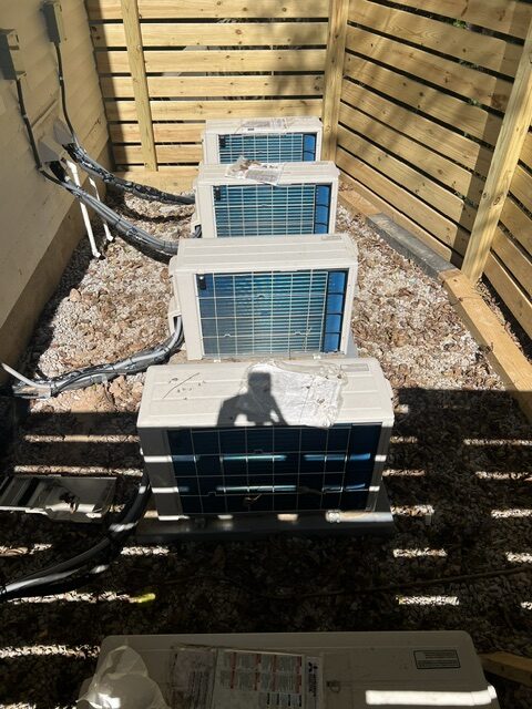 A bank of mini-split condensing units installed behind a screen wall