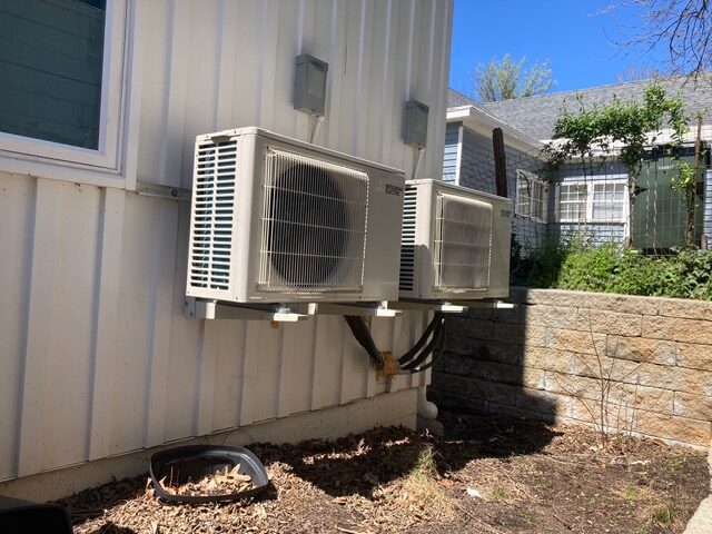Ductless mini-split condensers mounted on the exterior of a multi-unit building